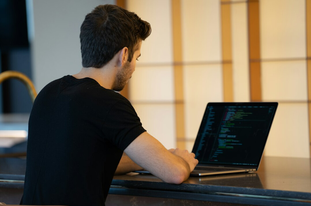 Team of software developers collaborating around a laptop in a modern office